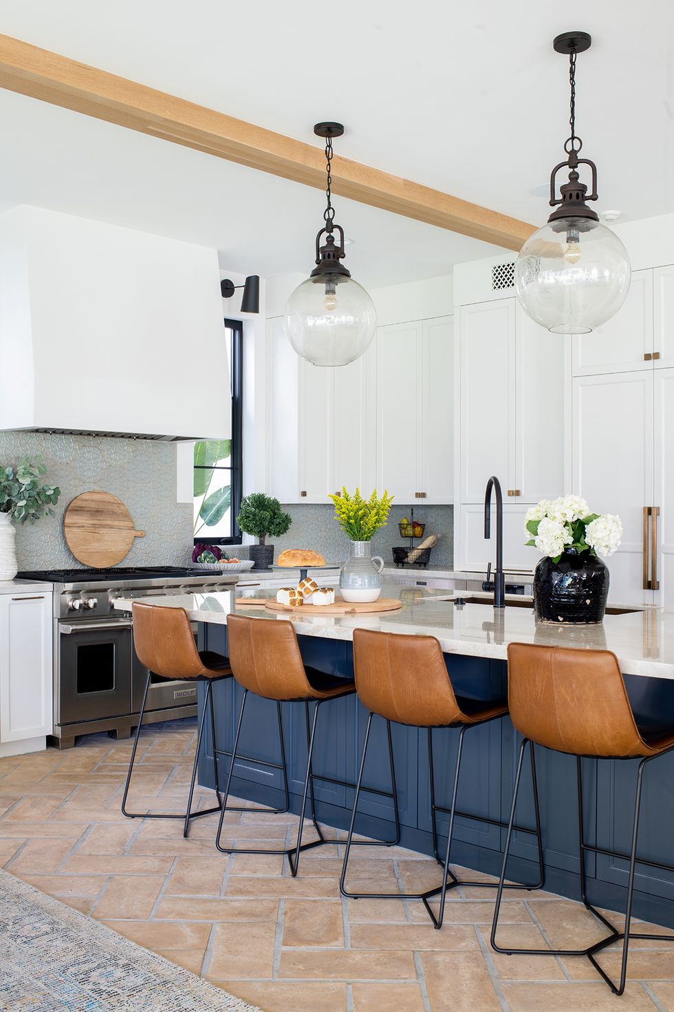 a kitchen counter with a table and chairs and globe pendant lights