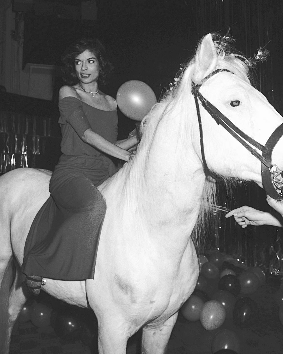 bianca jagger, the birthday girl, straddles an equine visito