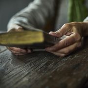 bible verses about anger person resting their hands on an old wooden surface and holding a bible