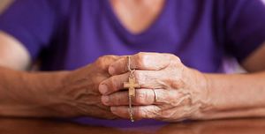 bible verses about anxiety woman with hands together holding a necklace with a cross