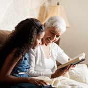 bible verses about family an older woman sitting on the sofa next to a girl and reading the bible together