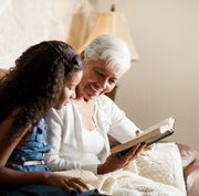 bible verses about family an older woman sitting on the sofa next to a girl and reading the bible together