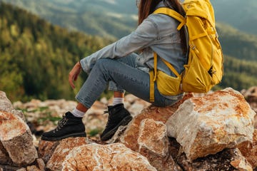 bible verses about fear young female taking a break and sitting on the rocks while hiking through the mountains