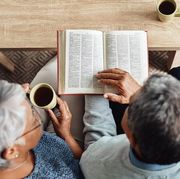 bible verses about love elderly couple sitting on a couch together reading the bible