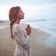 bible verses for women woman holding hands together in pray on a beach