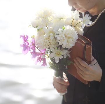 bible verses for funerals woman in black clothing holding a bible and bouquet for flowers