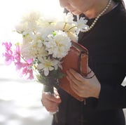 bible verses for funerals woman in black clothing holding a bible and bouquet for flowers