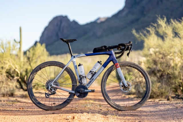 gravelbike op een gravelpad met begroeing en rotsen op de achtergrond