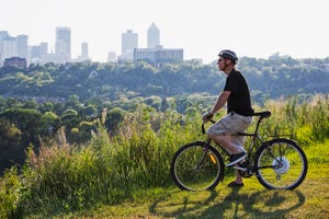 un hombre contempla la ciudad de edmonton sentado en su bicicleta eléctrica