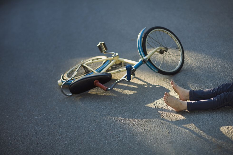 Child with bicycle fallen on street