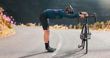 bike, street cycling and stretching with a sports man at the start of fitness, exercise or training on an asphalt road bicycle, stretch and workout with a male cyclist getting ready for a sport ride