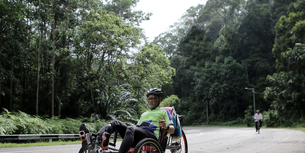 a muslim senior man is riding bike to fill in retirement days