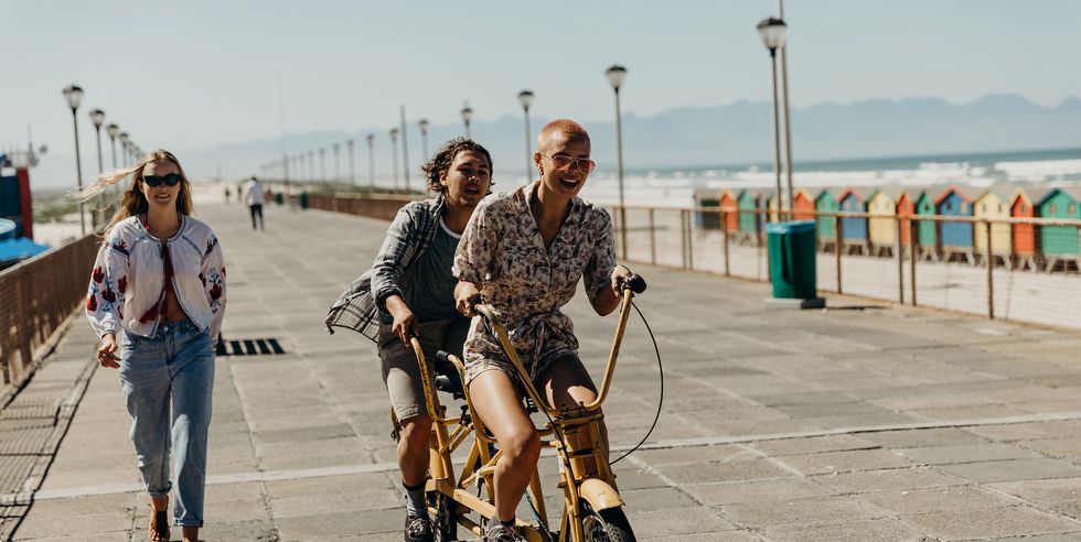 couple riding on a tandem bicycle on the boardwalk