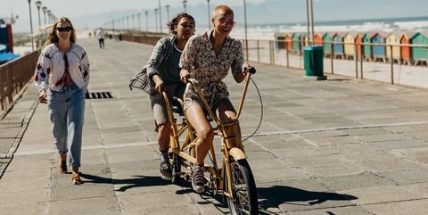 couple riding on a tandem bicycle on the boardwalk