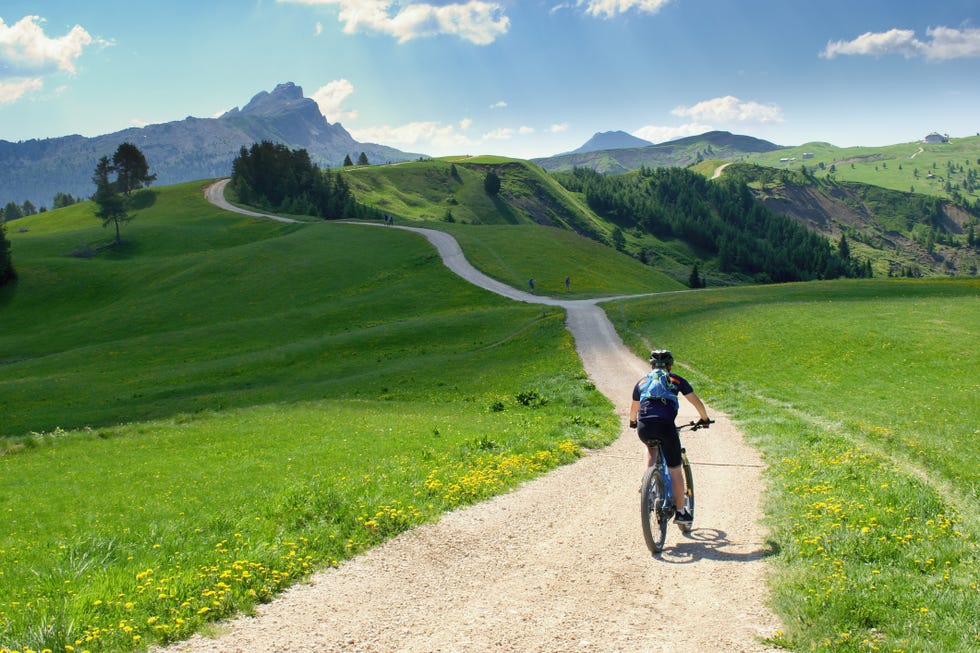 biker riding scenic path in beautiful summer mountain scenery , dolomites italy, european alps