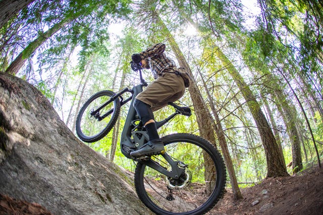 e biking up a steep rock on a mountain bike trail