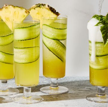cucumber in a pineapple juice and prosecco cocktail garnished with a pineapple wedge