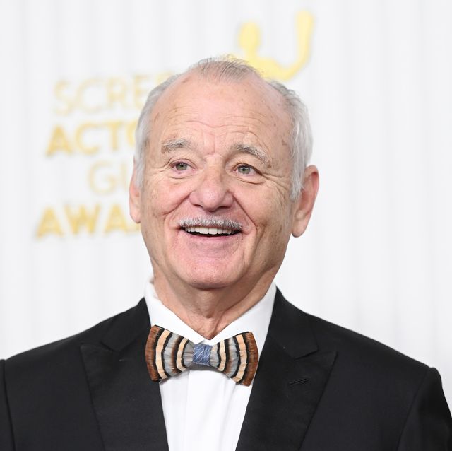 bill murray looks to the left of the camera and smiles, he wears a black suit jacket, whit collared shirt and multicolored bowtie
