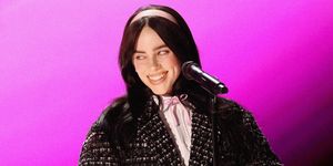 singer billie eilish smiling with a microphone