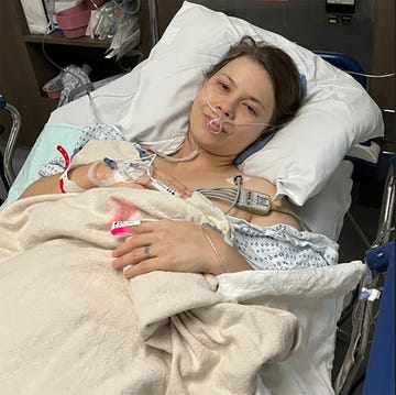 patient in bed with medical equipment and iv access