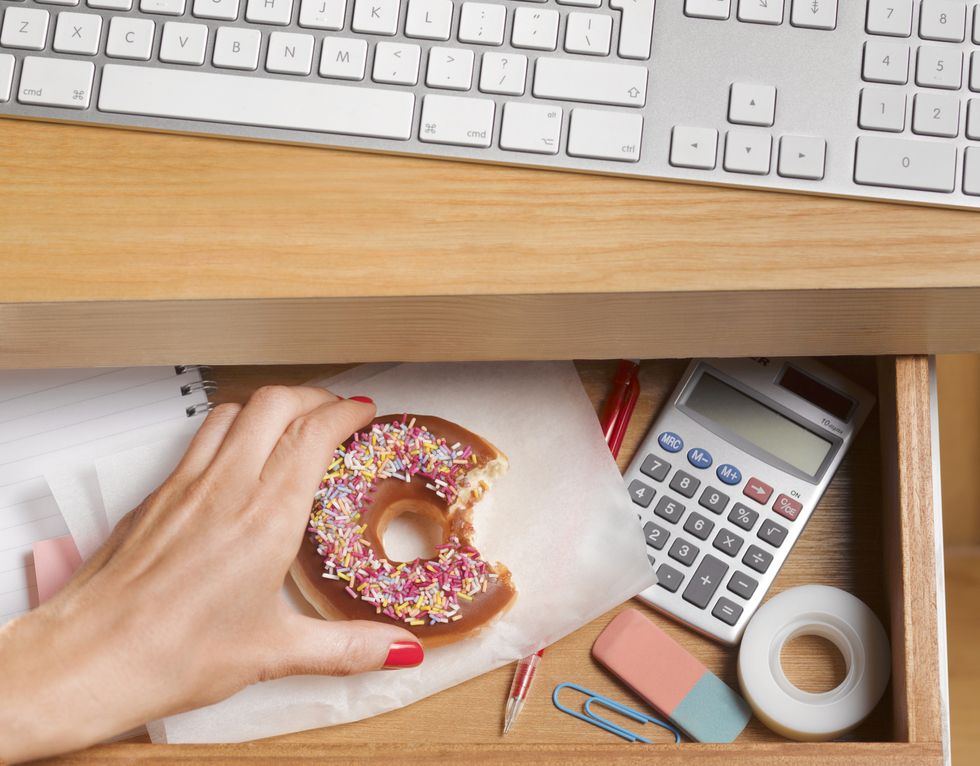 binge eater hiding doughnut in desk drawer