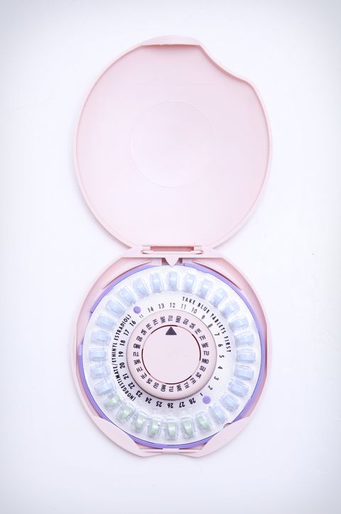 Birth Control Pills and Container on White Background