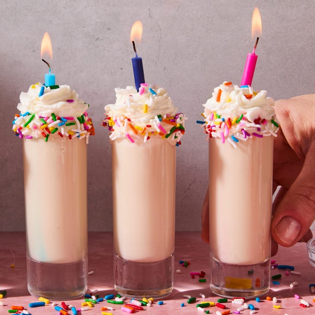 shot in a shot glass topped with sprinkles, whipped cream, and a candle