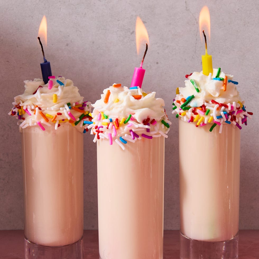 shot in a shot glass topped with sprinkles, whipped cream, and a candle