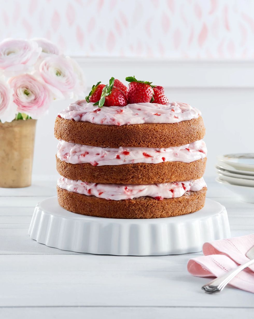 three layer strawberry limeade cake with strawberry frosting between the layers and strawberries on top