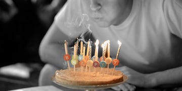 boy blowing out birthday candles on cake