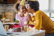 mother and daughter are in the kitchen celebrating birthday via video call
