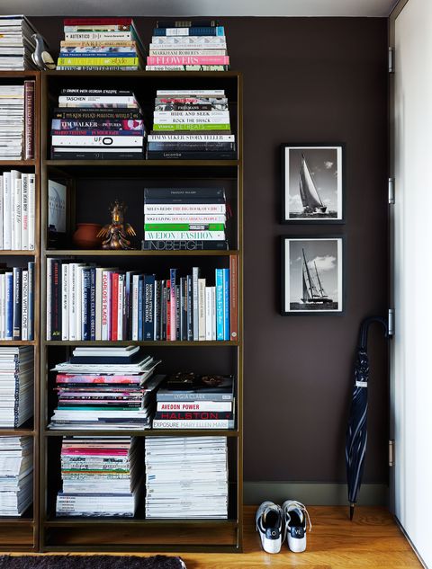 stuffed bookshelf in a dark brown hallway