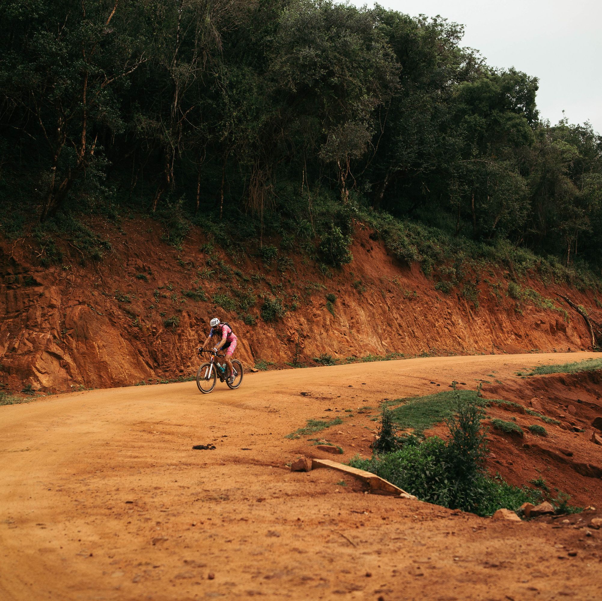 a cyclist riding on a dirt road