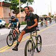 leo rodgers coasts down a hill on his handlebar during a critical mass ride in ybor city, florida in july 2018