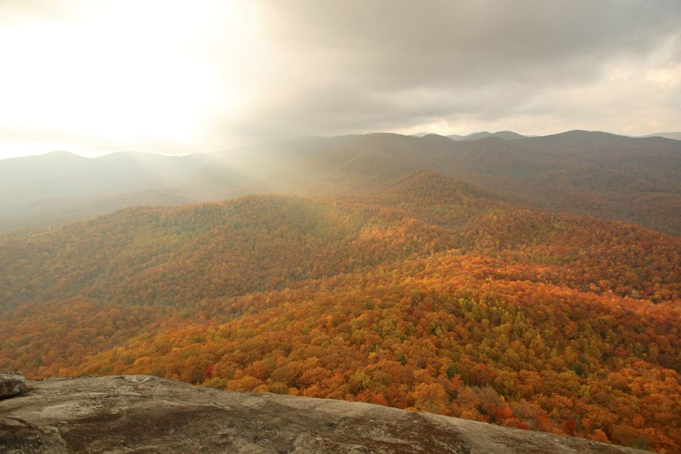 sunrays and fall colors from the summit of looking glass rock, nc in the pisgah national forest near brevard, nc travel awards 2022