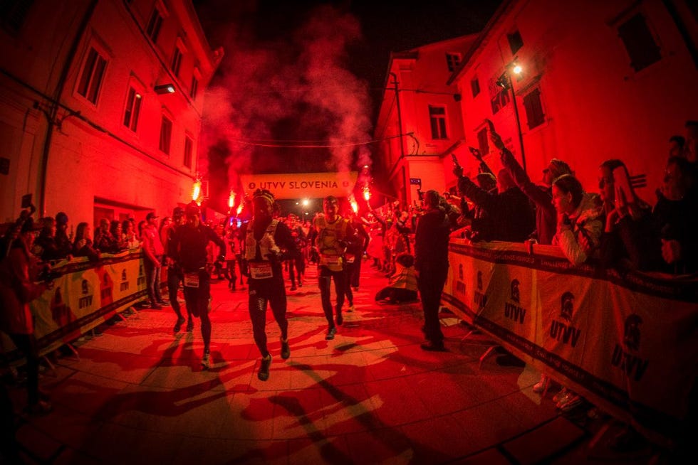 nighttime running event with participants and cheering spectators