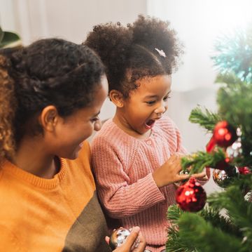 mother and her cute daughter decorating christmas tree for christmas and happy new concept