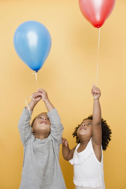 Black children holding helium balloons