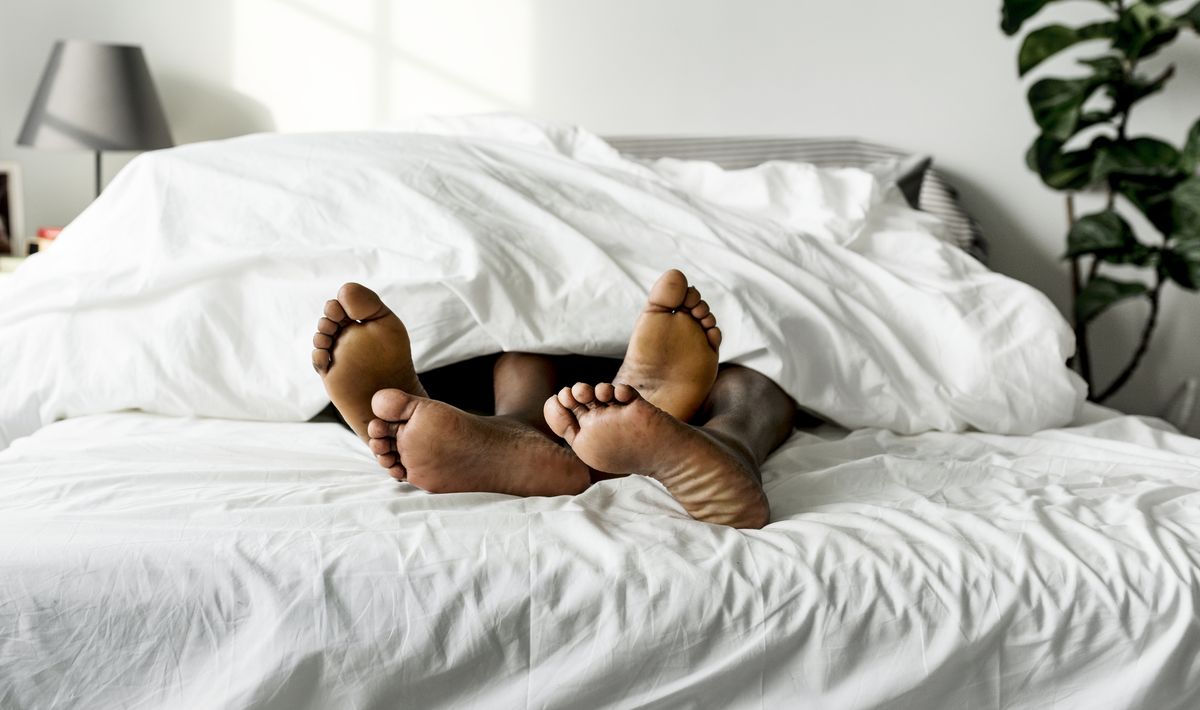 Black couple lying on bed together sex concept