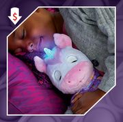 young girl holding unicorn toy in bed and kid's hand playing with fire engine toy