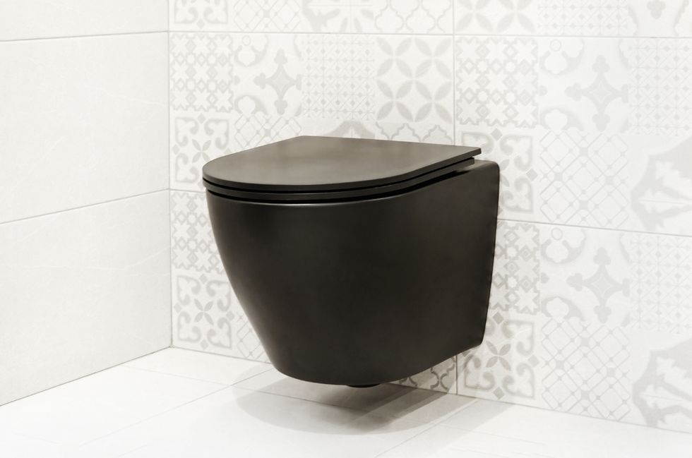 black hanging toilet against white wall modern wall mounted toilet in a tiled bathroom interior