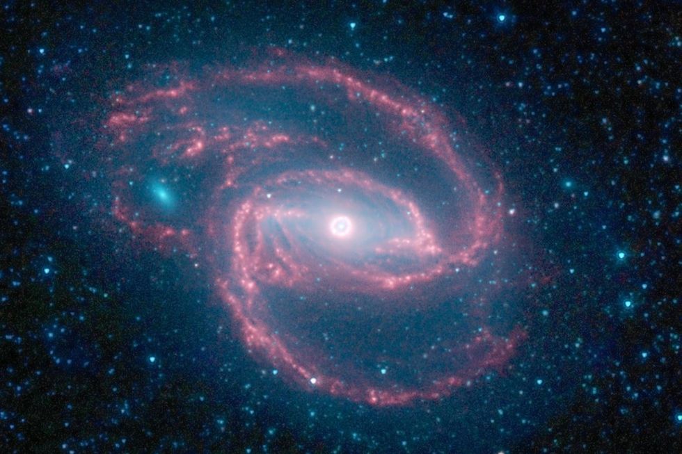 Gezien door de ogen van een NASAtelescoop toont dit verafgelegen sterrenstelsel een ring van sterren rondom zijn centrale zwarte gat