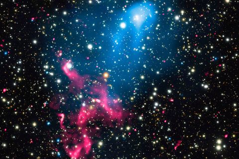 Twee op elkaar botsende sterrenstelsels stralen in verschillende golflengten terwijl ze de uitbarstingen van een superzwaar zwart gat aanzwengelen