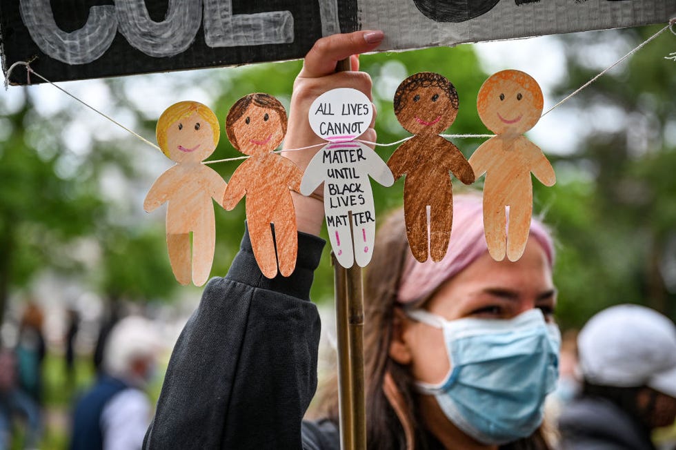 woman holding up sign that reads 'all lives cannot matter until black lives matter'