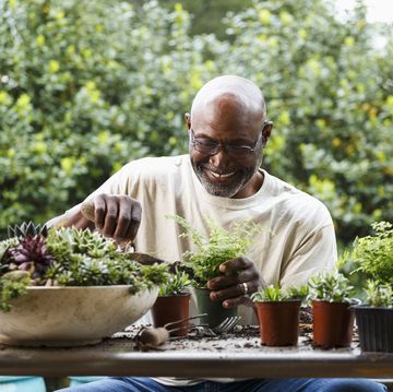 black man gardening at table outdoors