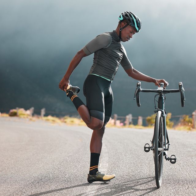 https://hips.hearstapps.com/hmg-prod/images/black-man-road-and-bicycle-stretching-fitness-or-royalty-free-image-1707245867.jpg?crop=0.64368xw:1xh;center,top&resize=640:*
