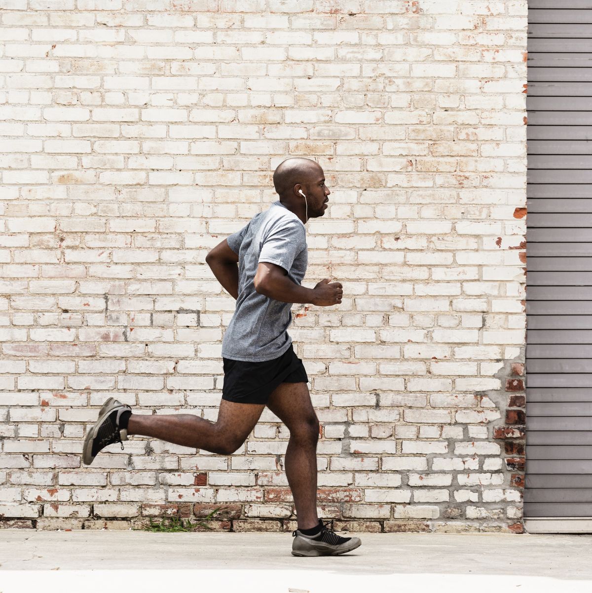 black man running on city sidewalk
