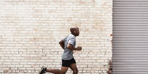 black man running on city sidewalk