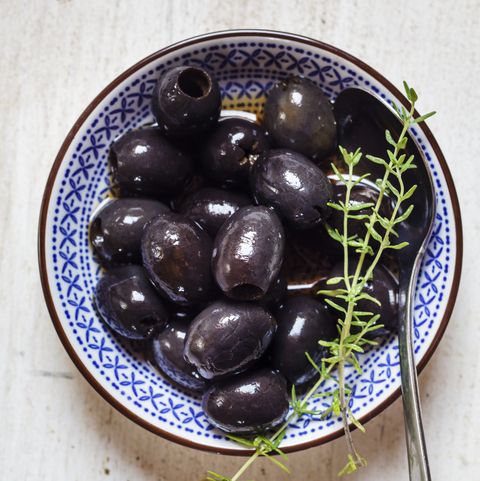 Black olives in bowl with thyme