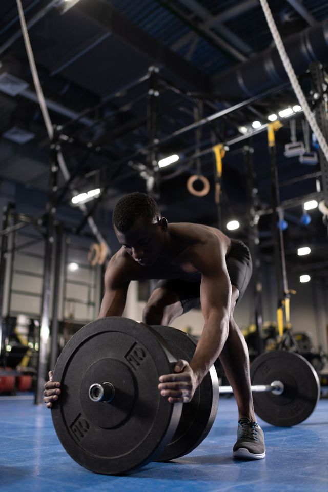 black sportsman preparing for deadlift exercise in gym